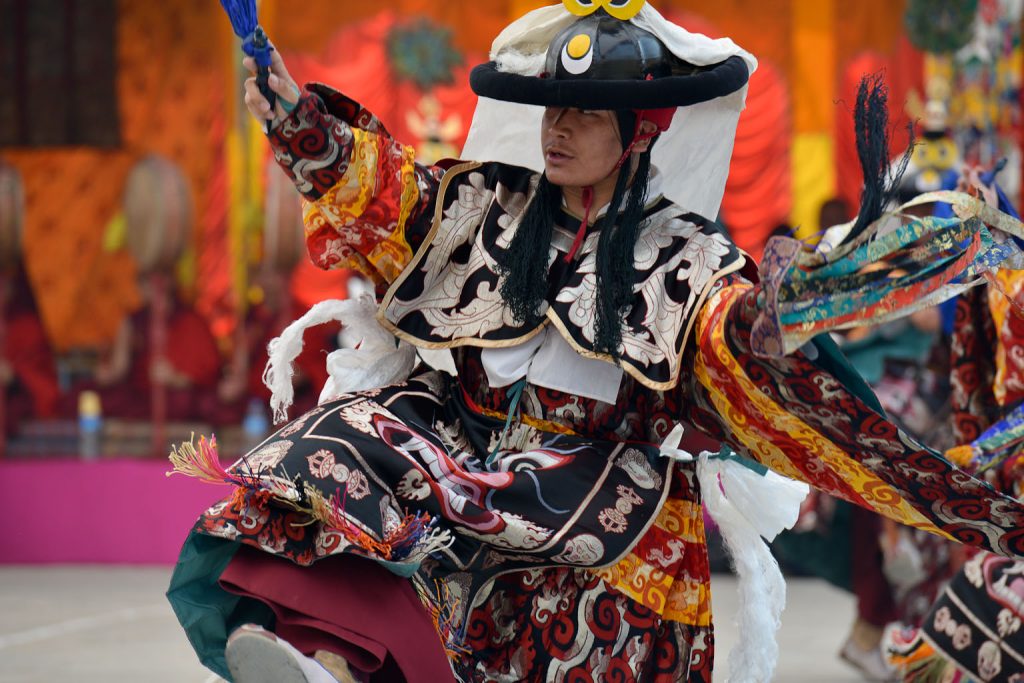 An un-masked monk performing a ritual Cham Dance.