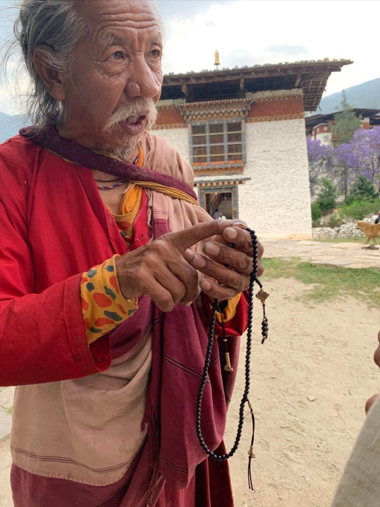 A Milarepa Nakpa yogi teaches Heather Elton proper mala technique.