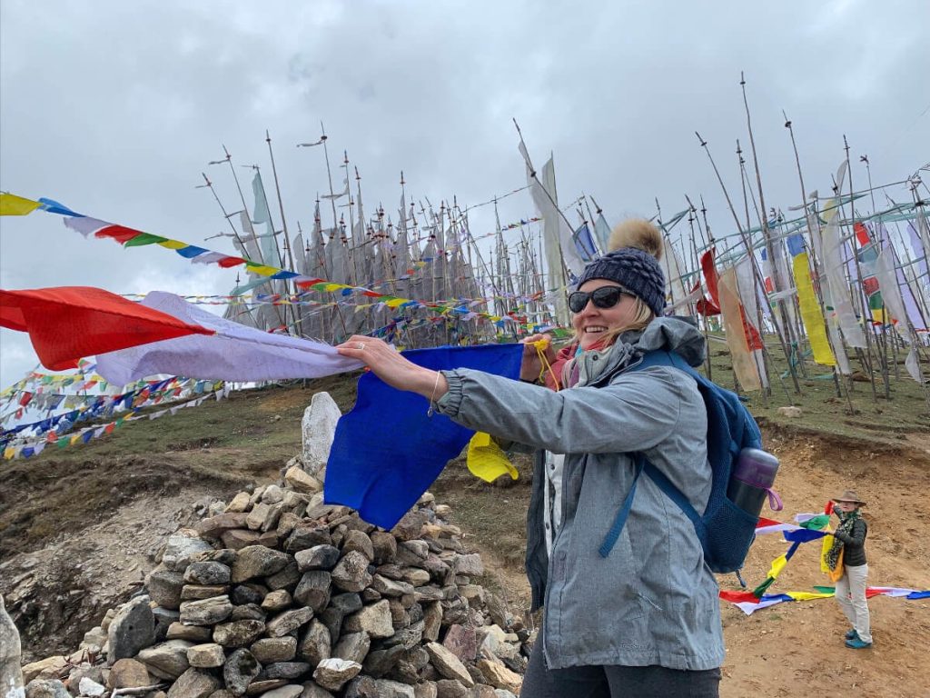 Students on the Bhutan Yoga adventure hanging prayer flags at 4000 m (about 13,000 feet) above Chela La Pass