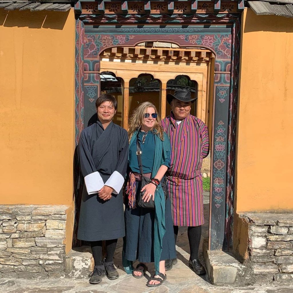 Heather standing with Jigme the guide on the Bhutan Yoga Adventure and Dorje their driver.