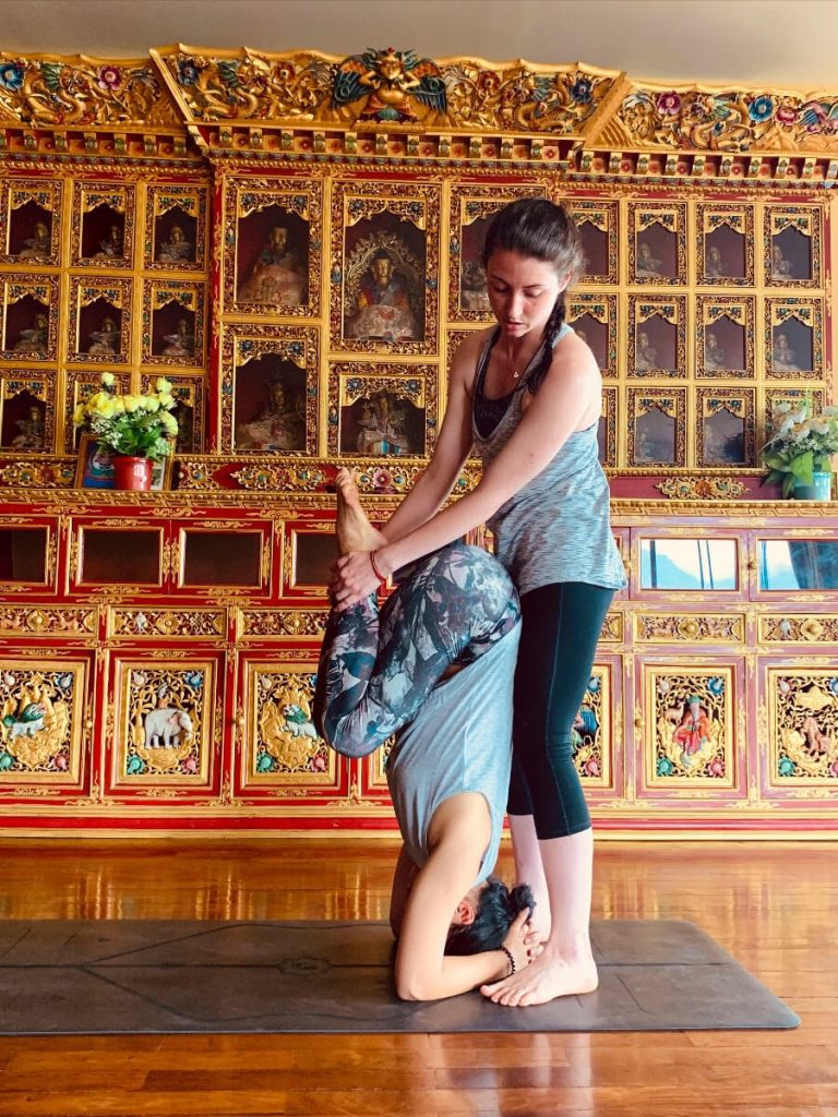 Student on the 2019 Yoga Teacher Training in Nepal demonstrating a headstand adjustment.