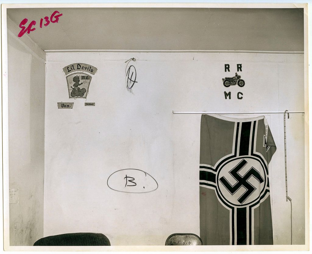A black and white photograph of a wall bearing the nazi flag at the crime scene where Sidney Albert MacDonald was murdered. Satans Angels clubhouse on Napier Street, Vancouver.